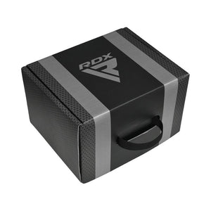 A black and gray foam yoga block with a textured surface, black handle, and the RDX logo printed on top.