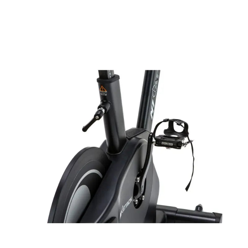 The Attack Fitness M1 Magnetic Studio Bike by Attack Fitness is a black belt-driven indoor cycle with console, featuring an adjustable seat, handlebars, and large flywheel—ideal for indoor cycling workouts against a white background.