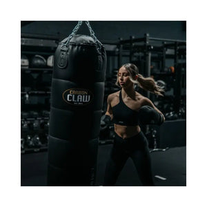 The Carbon Claw Pro FX-7 Series 4FT Heavy Punch Bag (45kg, foam padded) in black synthetic leather with chain attachments and logo is designed for boxing training, shown hanging against a plain white background.