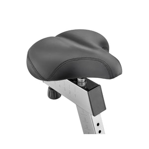 A close-up of a black, padded bicycle seat with visible stitching, mounted on a silver adjustable seat post marked with numbers for height settings.