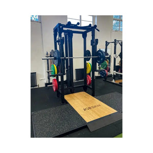 The JORDAN J75 Adjustable T Rack Cable Machine is a black all-in-one pulley and power rack system with Jordan-branded blue and red weight plates—perfect for versatile strength training using cables, pulleys, and bars.