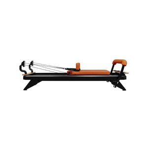 The HEGREN TALMA 62 Pilates Reformer by Hegren features a studio-grade steel frame in black and orange, adjustable straps, padded seat, and headrest. Shown from the side against a white background. Fast UK delivery available.