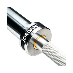 Close-up of the JORDAN Lightweight Aluminium Technique Bar—7kg, 1830mm Olympic training barbell—with a textured grip, silver finish, gold ring detail, and the Jordan logo on the end cap; ideal for technique work.