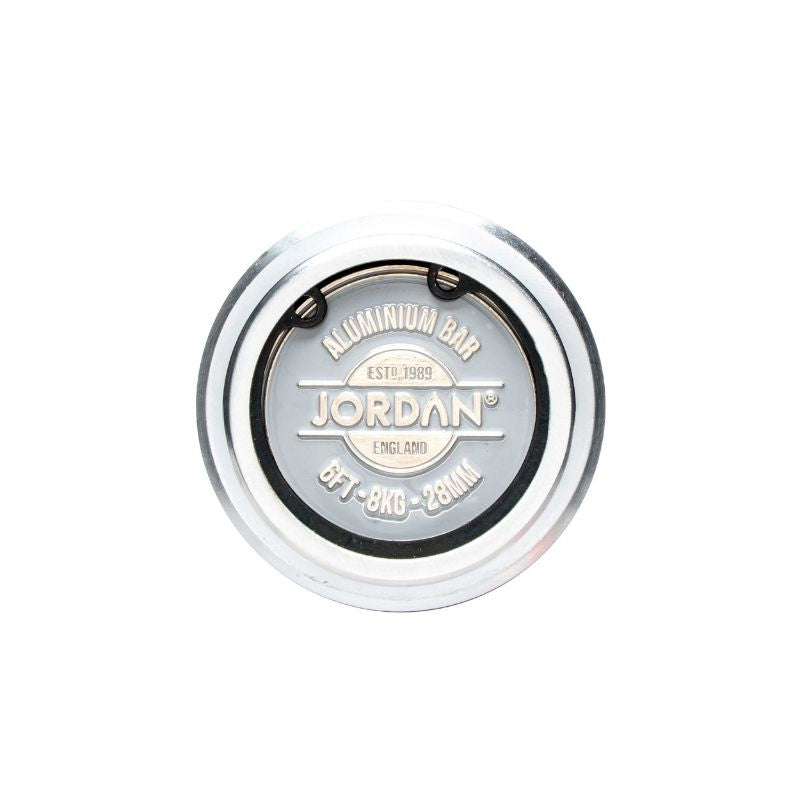 A silver Jordan aluminum weight plate, engraved with EST. 1989, JORDAN, ENGLAND, 8FT - 8KG - 28MM, pairs perfectly with the JORDAN 7ft Open-Ended Trap Bar—an Olympic hex bar featuring dual handles and a loading jack.