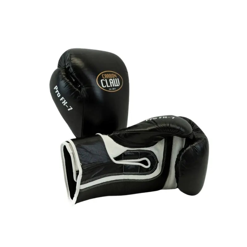 A pair of Carbon Claw Pro FX-7 Series Sparring Gloves in black and white genuine leather—one upright, one flat on a white background. Featuring ergonomic fit and wrist support, ideal for sparring sessions.