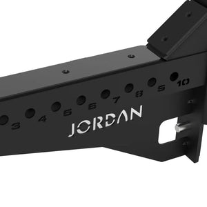 Positioned in parallel, the JORDAN J75 Safety Sport Arms Attachment (pair) features two black metal brackets with multiple holes, red wires, and an angled rectangular base. The Jordan brand name is visible in white, ensuring reliability for heavy lifting in strength training setups.