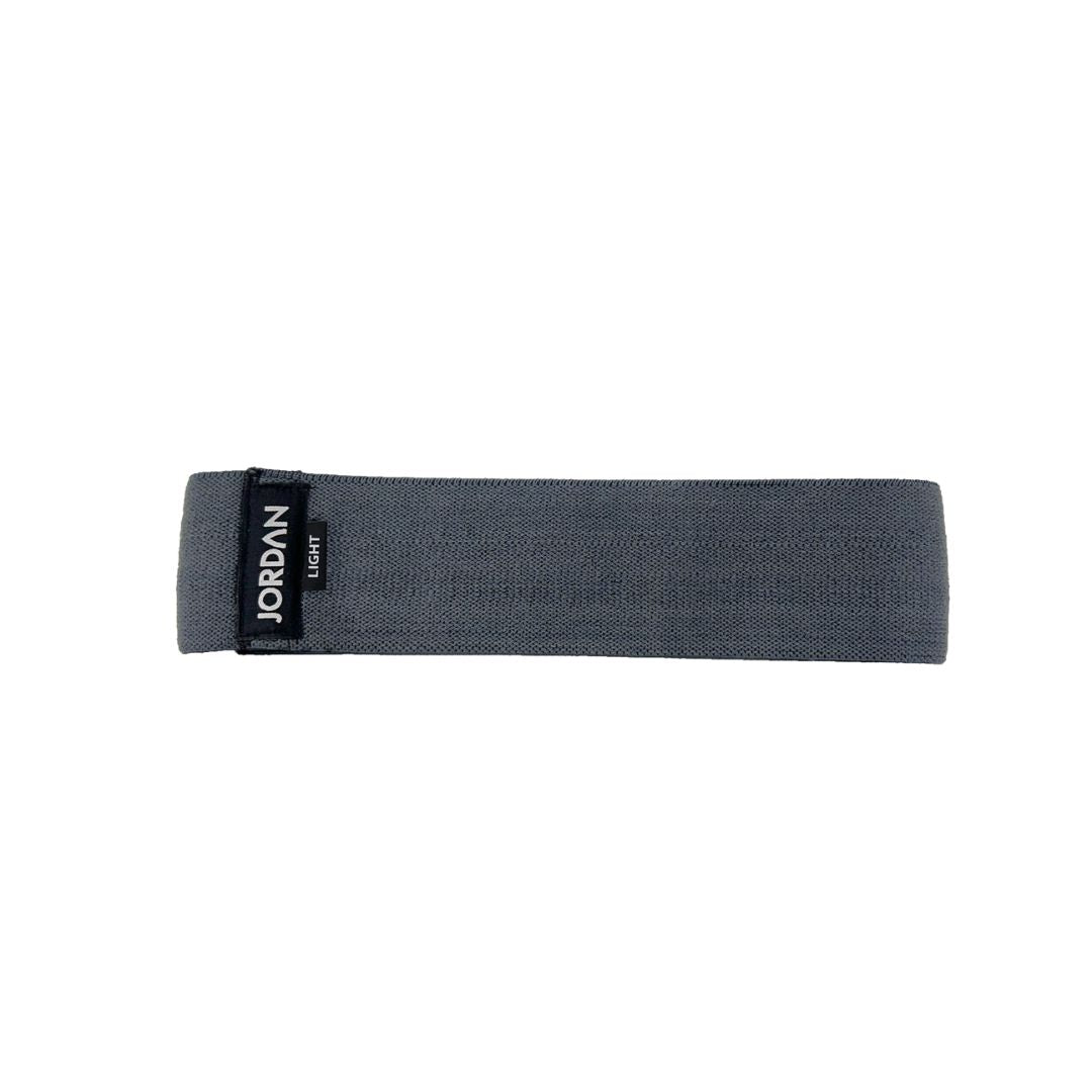 The JORDAN Fabric Resistance Band is red with Jordan and Medium on a black label, offering a smooth texture and moderate elasticity. Its durable design makes it perfect for fitness and strength training, providing versatile workout options.
