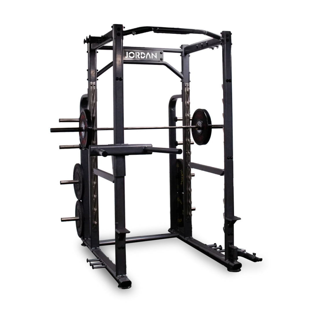 The JORDAN Power Rack with Attachments, by Jordan, is a commercial-grade black and red power rack featuring weight holders and pull-up bars designed for strength training. It stands prominently against a plain white background.