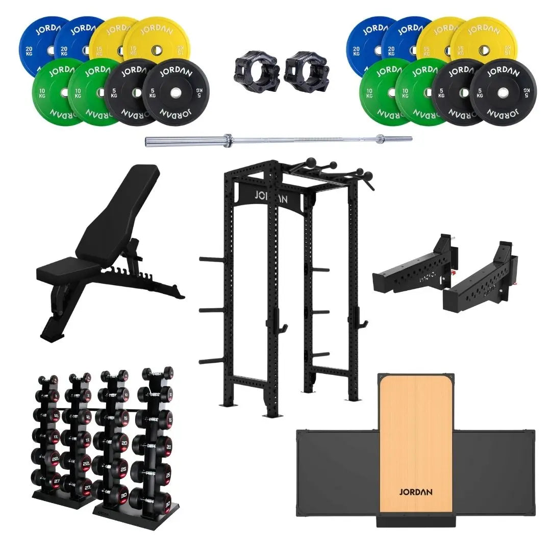 A home gym setup with colorful weight plates, a barbell, squat rack, adjustable bench, dumbbells on racks, barbell clamps, dip bars, and a plyometric box, all branded JORDAN.
