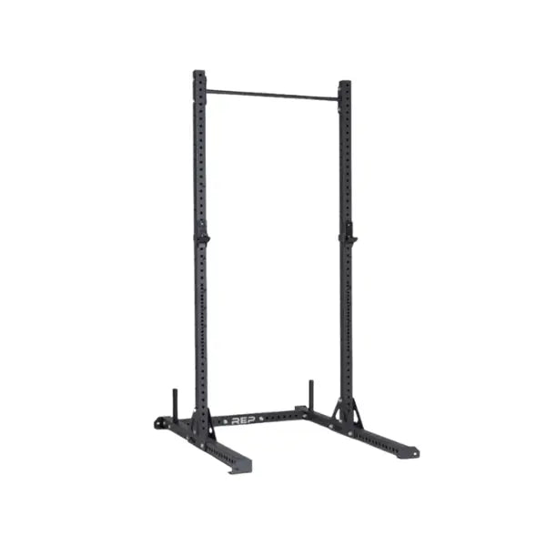 Black metal squat rack with adjustable safety bars and a pull-up bar at the top, designed for weightlifting and strength training. The rack stands on a sturdy base with angled supports.