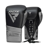 A pair of black and silver RDX - Mark Pro TRI LIRA Boxing Gloves with laces, made from Super Skin combat leather and TRI LIRA MOULD tech, placed on a white background.