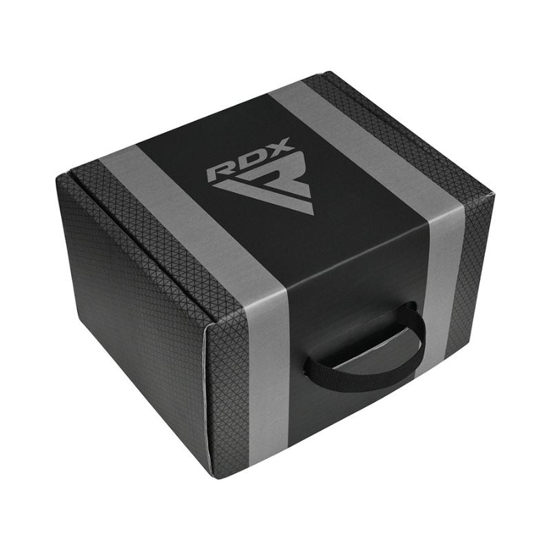A black and gray foam yoga block with a textured surface, black handle, and the RDX logo printed on top.