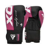 A pair of black and pink boxing gloves with white RDX branding, one glove standing upright and the other resting on its wrist strap, showing both the front and palm side.