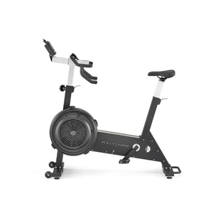 A stationary exercise bike with a large front fan wheel, adjustable seat and handlebars, black frame, and a small digital display mounted on the handlebars.