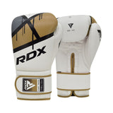A pair of white RDX boxing gloves with gold and black accents, featuring bold "RDX" branding. One glove is shown palm-up and the other palm-down, displaying their design and wrist straps.