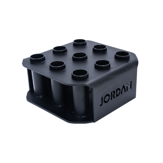 The JORDAN Olympic Bar Holder by Jordan is a black, rectangular rack with nine vertical slots for organizing Olympic bars upright, featuring the brand name cut out on the side.