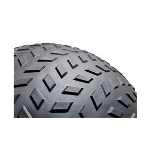 Close-up view of the tread pattern on a black slam ball showing a geometric, diamond-shaped design on a curved surface against a white background.