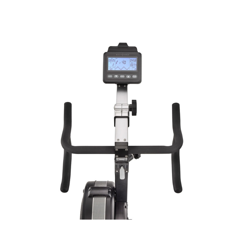 Front view of a stationary exercise bike showing its handlebars, digital display screen with controls, and part of the bike’s frame against a plain white background.