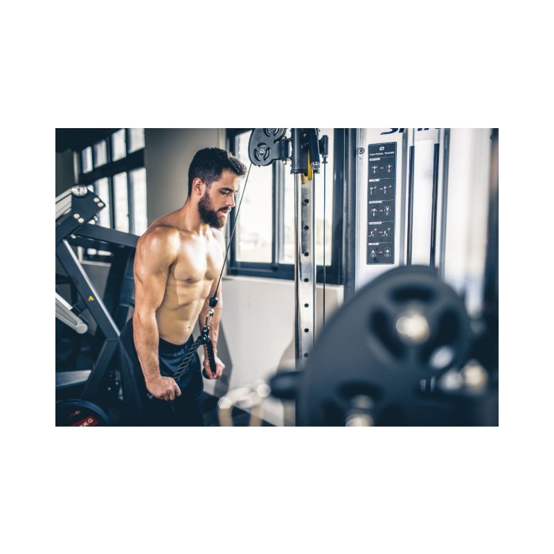 Man standing in a gym with exercise equipment in the background