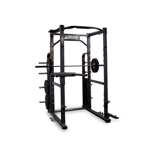 The JORDAN Power Rack with Attachments, by Jordan, is a commercial-grade black and red power rack featuring weight holders and pull-up bars designed for strength training. It stands prominently against a plain white background.