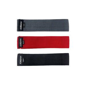The JORDAN Fabric Resistance Band is a non-slip booty band for squats, lunges, and glute workouts. Shown in red with a black Jordan Medium label against a white background.