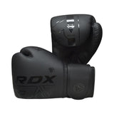 A pair of black RDX boxing gloves are displayed, with one glove standing upright and the other resting on its side, showcasing their sleek design and glossy logo accents.