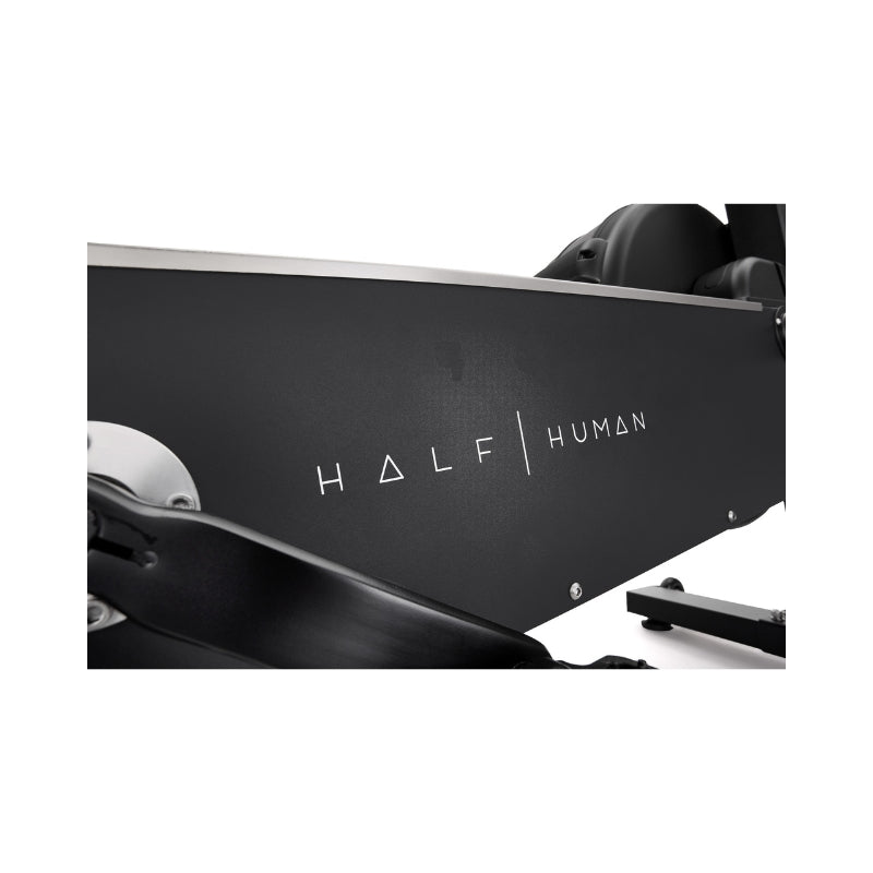 Close-up of a black exercise machine with the brand name "HALF HUMAN" printed in white letters and geometric shapes on the side.