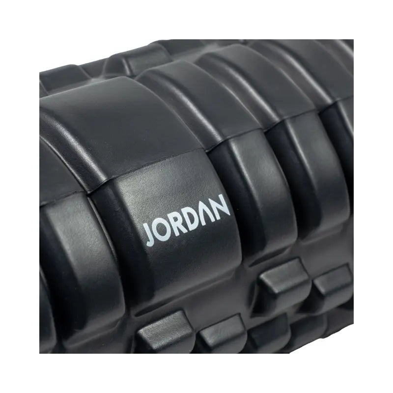 The Jordan Medium-Density Massage Roller – Everyday Foam Roller features a textured black, grid-like surface with Jordan printed in white, perfect for daily recovery and muscle relief. Pictured horizontally on a white background.