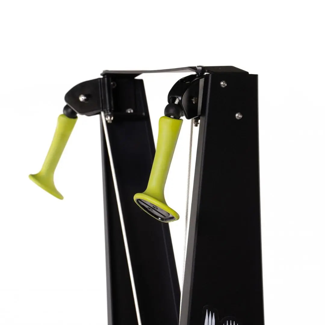 The ATTACK FITNESS Ski Attack is a sleek black ski trainer with green-accented handles, designed for a full-body workout. It features two vertical poles, handles, and a digital display. The sturdy base includes a fan mechanism for resistance, perfect for Nordic skiing enthusiasts.