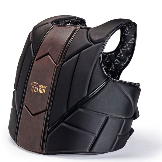 The CARBON CLAW - RECOIL RB-7 Coach Tech Guard features black padded sections, a dark brown central panel for midsection protection, and the Carbon Claw logo on the chest. It includes adjustable straps for a custom fit and an interior lining with a stylish repeating graphic pattern.