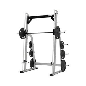 The EXIGO Plate Loaded Smith Machine by Exigo is a silver and black weightlifting system with barbell and weight plates, designed for strength training, shown isolated on a white background.