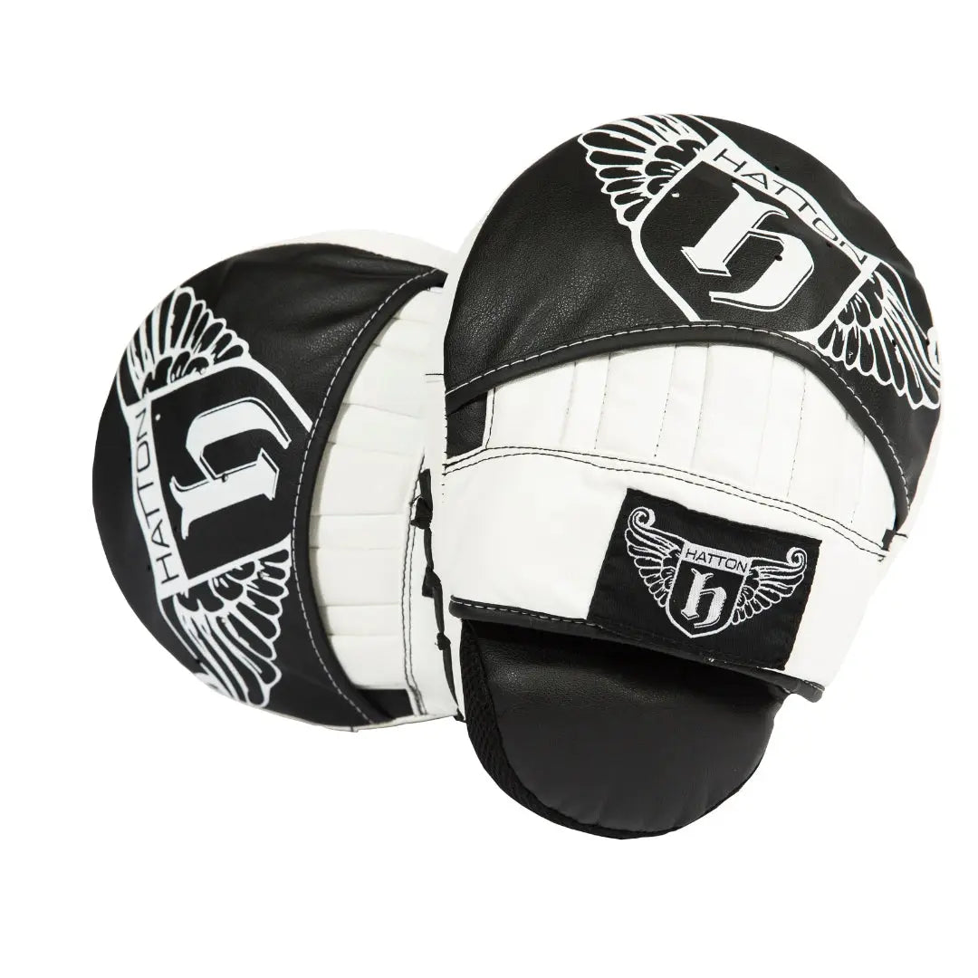 The HATTON BOXING Curved Focus Hook & Jab Pads by Hatton are black and white with a winged H logo on each pad. Designed with shock-absorbing foam, these pads feature bold black text and stylish graphics for an optimal training session.