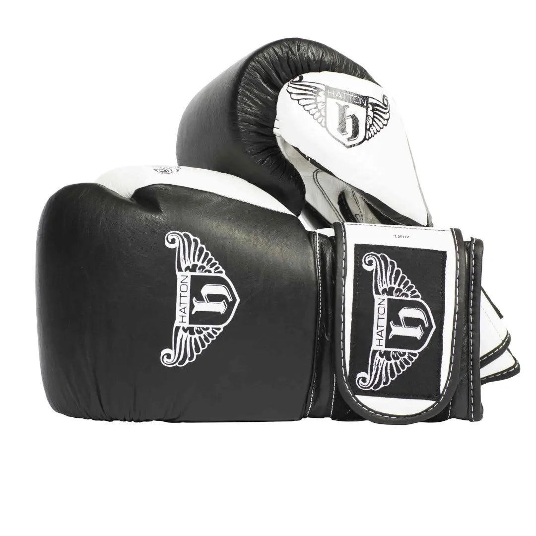 HATTON BOXING Velcro Sparring Gloves Leather, featuring the Hatton logo and a stylized H. These sleek black-and-white gloves include intricate white detailing, perfectly positioned for any boxing routine.