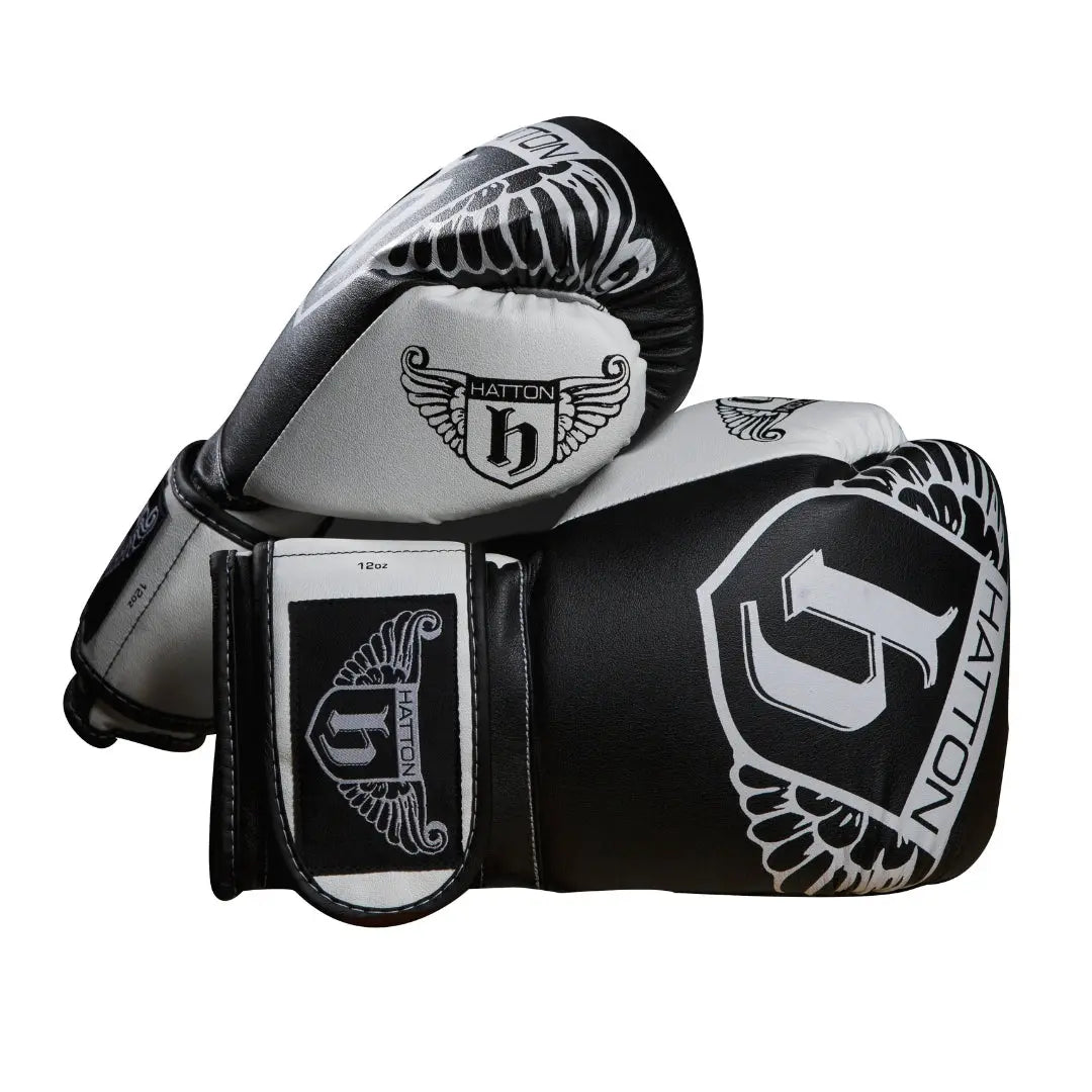 The sleek HATTON BOXING Boxing Gloves PU in black and white, featuring the Hatton brand and a winged logo, are shown overlapping against a white background.