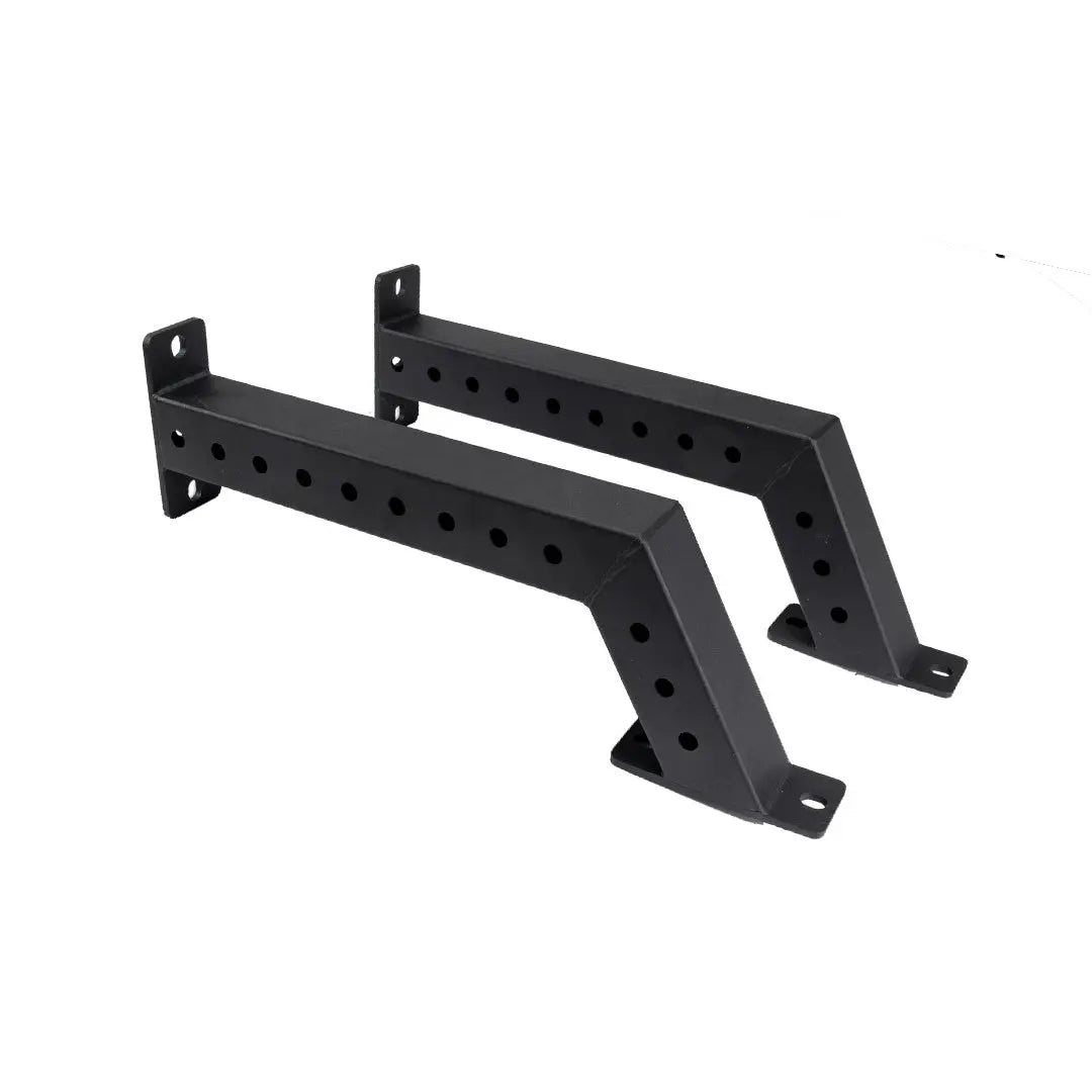 The Jordan Helix Fixed Power Rack Foot Attachments (pair) are black metal wall brackets with a Z-shape and multiple circular holes for mounting. These commercial-quality components are perfect for supporting shelves or racks, ensuring sturdy attachment in gym settings.