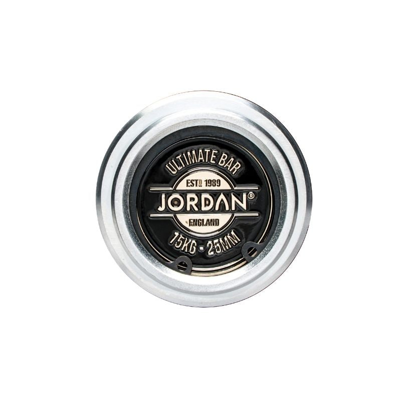 A close-up of a JORDAN Ultimate Olympic Bar end cap, labeled with the brand and weight (15kg), in silver and black with a metallic ring—perfect for men’s & women’s competition-standard barbell users and powerlifters.