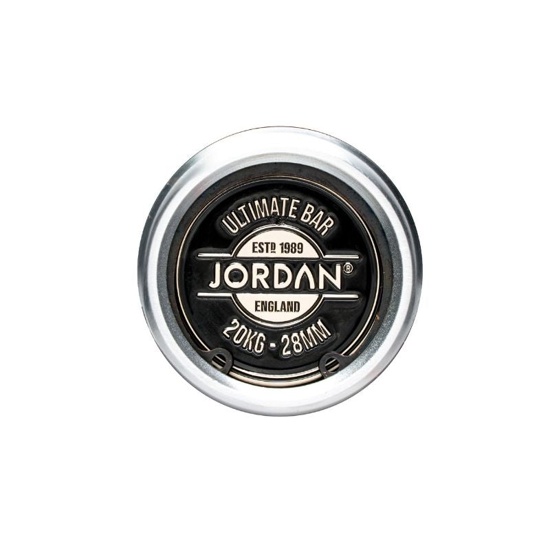Close-up top view of a JORDAN Ultimate Olympic Bar end cap, labeled with the brand name and weight—20KG, 28MM—with a black center and silver outer ring; perfect for men’s & women’s competition-standard barbells.