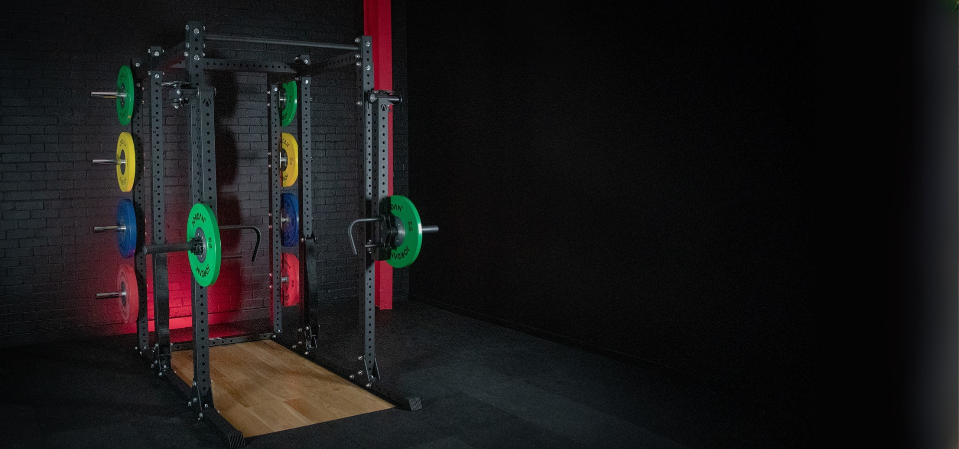 Gym weight rack with colorful weights against a dark background
