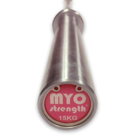 A close-up of the MYO Strength - 7ft Olympic Bar (1000lbs Tested) – 15kg end shows a pink label with white MYO Strength 15KG text, emphasizing its durability and robust build.