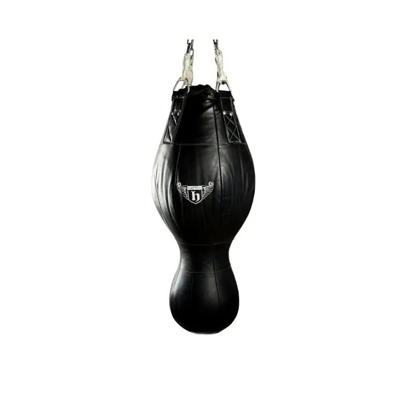 The Hatton Boxing Triple Punch Bag, a black teardrop-shaped 3-in-1 training bag with leather and PU options, hangs from metal chains. It features a white winged logo on the upper section and is ideal for versatile boxing workouts.