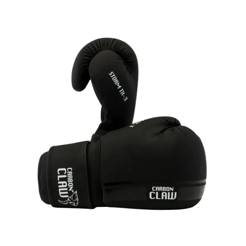 The CARBON CLAW -Storm TX-3 Series Sparring & Training Boxing Glove in black synthetic leather features the Carbon Claw brand and a white claw logo on the wrist strap and glove, set against a plain white background.
