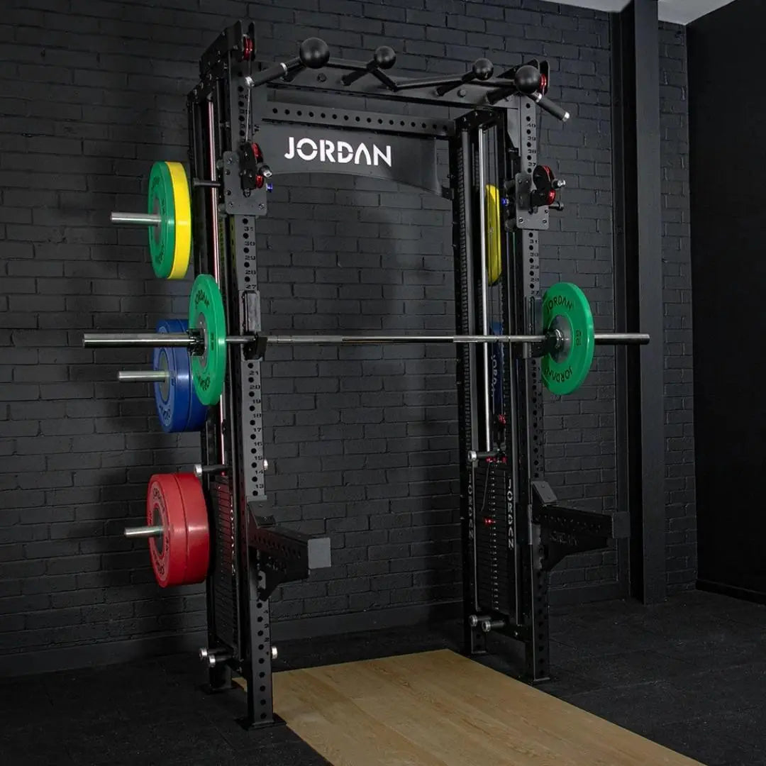 The JORDAN -J75 Cable Rack in black is a versatile gym power rack with barbells and weight plates on both sides. It features storage for weights and equipment, making it ideal for strength training exercises. The top arch is labeled Jordan.