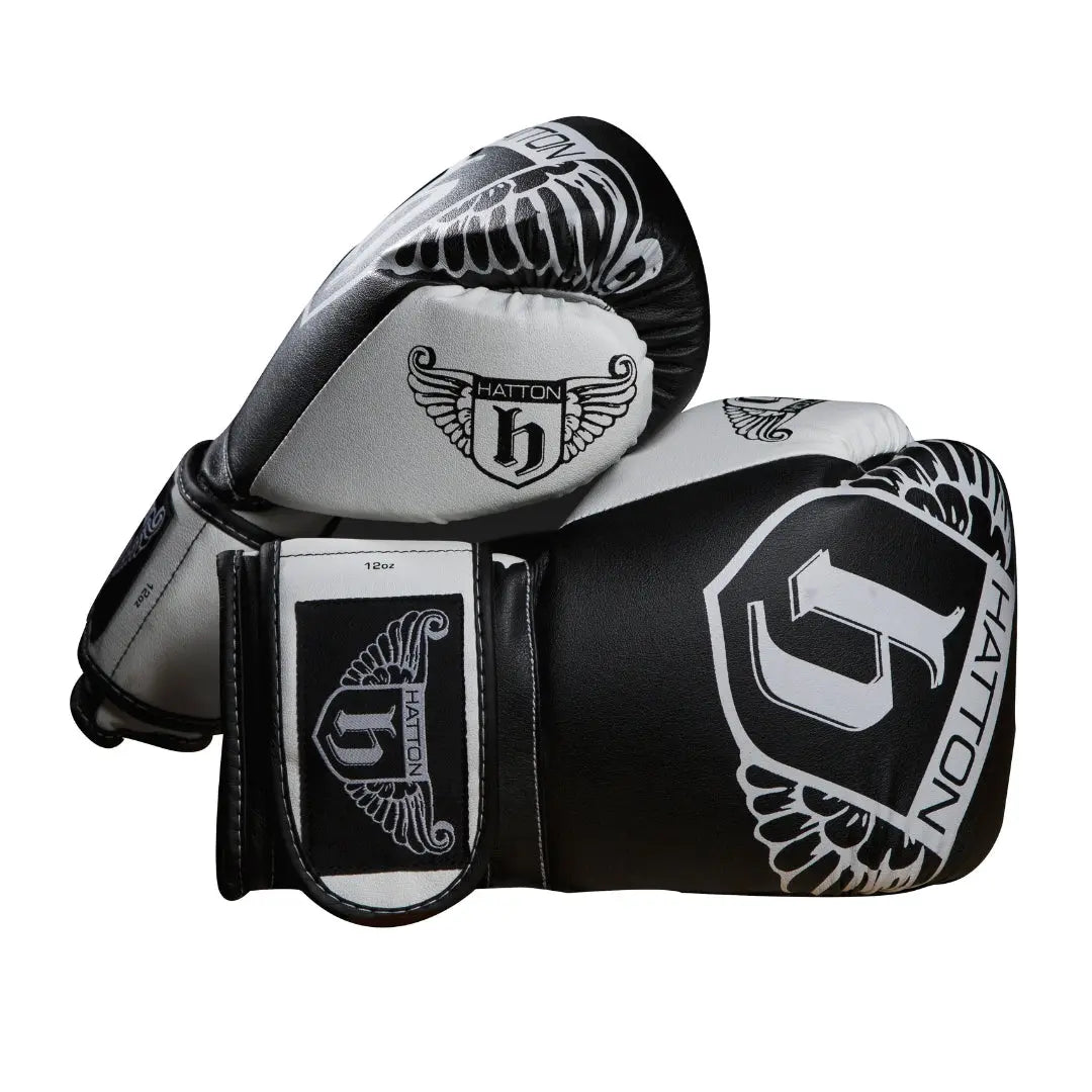 The sleek HATTON BOXING Boxing Gloves PU in black and white, featuring the Hatton brand and a winged logo, are shown overlapping against a white background.